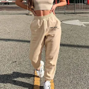 Full-length view of beige high-waist sweatpants with elastic cuffs and pocket.