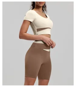 Detail shot of color-block yoga set featuring slim fit short sleeve top and brown shorts.