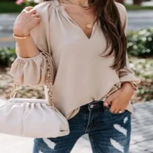 Detail view of stylish beige V-neck long sleeve blouse with elegant lantern sleeves