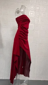 Detailed side view of a red strapless evening dress with high slit and ruffles.