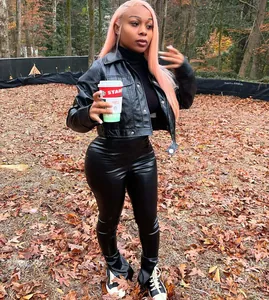 Stylish woman wearing black high stretch PU leather pants with split hem in autumn forest setting