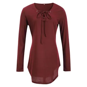 Macro detail view of the lace-up V-neckline design on a wine red long-sleeved tunic top.