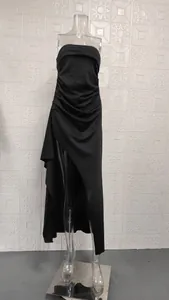 Detailed view of black strapless long dress featuring elegant pleats and a high slit design.