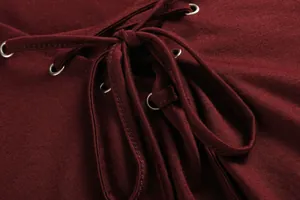Close-up detail of a burgundy V-neck lace-up top featuring metal eyelets and fabric texture