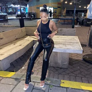 Detailed view of black PU leather slim fit pants with side slit hem for women