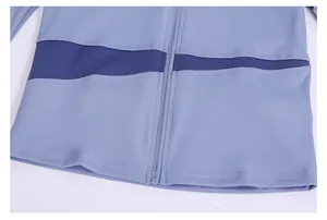 Detailed view of the blue color-blocked yoga jacket featuring premium zipper and seam detail.