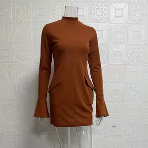 Detail view of rust brown long sleeve mini dress with flared cuffs and mock neck.