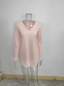 Detailed view of a stylish pink long-sleeved V-neck lace-up top displayed on a mannequin.