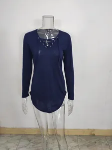 Detailed view of navy blue long sleeve V-neck top with front lace-up detail and curved hem