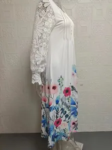 Detail of white long sleeve dress with elegant lace sleeves and floral print hem