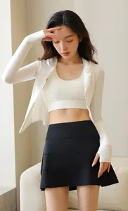 Asian female model wearing a high-waist black pleated tennis skirt and white jacket