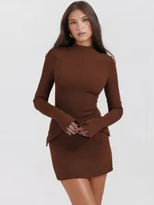 Close-up of elegant chocolate brown long sleeve bodycon mini dress with unique hip flaps