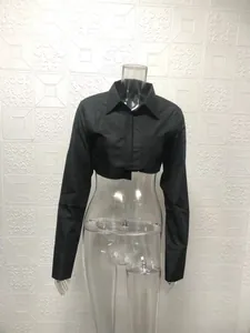 Detailansicht eines schwarzen bauchfreien Langarmshirts auf einer Schaufensterpuppe.