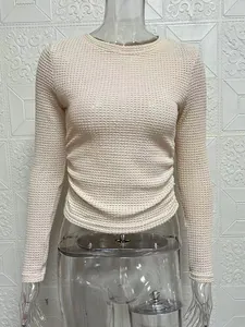 Close-up view of a women's cream long sleeve round neck slim fit textured knit top