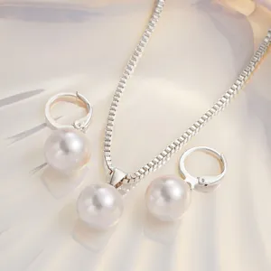 Primo piano di un elegante set di gioielli con perle, collana e orecchini a cerchio.