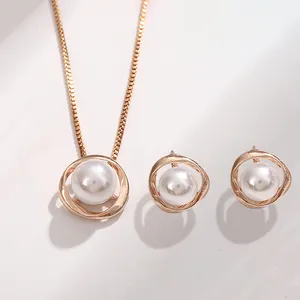 Dettaglio macro di un set con collana di perle e orecchini a lobo in oro rosa
