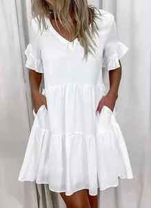 Close-up view of a white V-neck tiered mini dress with ruffle sleeves and pockets.