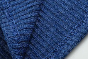 Macro dettagliata che mostra la trama e le cuciture del tessuto in maglia a coste blu