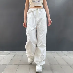 Detail of white low-waist cargo pants featuring an elastic drawstring waist and wide-leg fit.