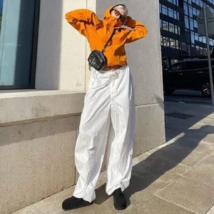 Detail view of stylish white low waist wide leg cargo pants with a drawstring waist