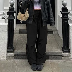 Black low-waist drawstring wide-leg cargo pants styled with a leather jacket and bag