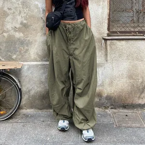 Olive green oversized cargo pants with drawstring waist shown in a street style look