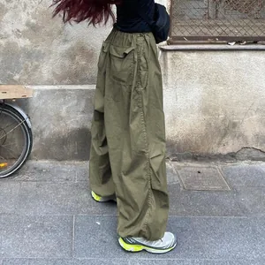 Street style view of olive green loose wide-leg cargo pants with drawstring waist detail
