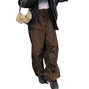 Close-up of brown low-waist cargo pants with drawstring and wide-leg fit for a Y2K look.