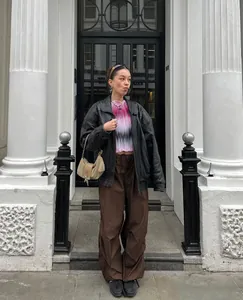 Full body shot of trendy brown wide-leg cargo pants styled with a black leather jacket