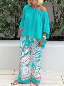 Women's summer outfit featuring a turquoise off-shoulder top and printed wide-leg pants