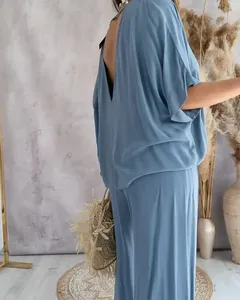Elegante vista trasera de un conjunto informal azul con cuello en V, mangas murciélago y pantalón