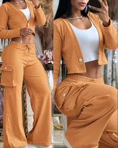 Detalle del conjunto cargo naranja de dos piezas con cárdigan y pantalón ancho.