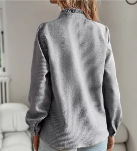 Detailed back view of a long-sleeved bubble seersucker shirt with a ruffle stand collar.