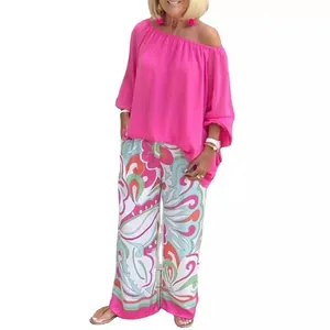 Women's two-piece casual set with pink off-shoulder top and floral wide-leg pants