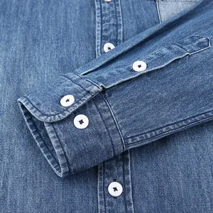 Dettaglio di una camicia denim da uomo in cotone blu a maniche lunghe con bottoni bianchi