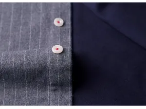 Close-up of gray striped fabric texture and white buttons on a warm men's shirt detail view
