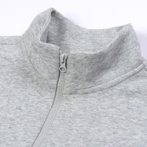 Detail view of a men's grey half-zip sweatshirt featuring a sturdy standing collar