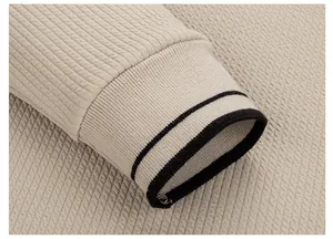 Makroansicht des gerippten Ärmelbündchens und der Waffelstrick-Textur dieses Herrenpullovers