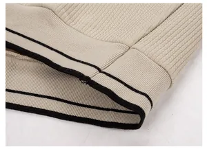 Detaillierte Ansicht des beigen Herren-Strickpullover-Saums mit schwarzen Streifen