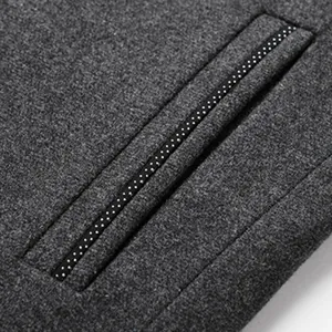 Detalle de cerca del bolsillo decorativo en un abrigo de invierno de lana gris para hombre.