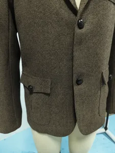 Nahaufnahme eines braunen Herren-Blazers im Fischgrätmuster mit klassischen Knöpfen