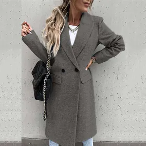 Full length view of a woman wearing a long grey wool coat with a classic blazer collar design