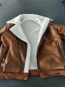 Close-up detail of a men's brown shearling jacket with warm white fleece lining