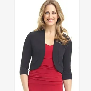Close-up of black cropped cardigan shrug for women over a red dress