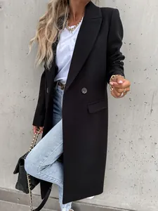 Detailed view of an elegant long black wool coat with stylish gold accessories.