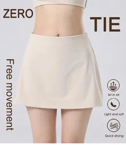 Detail of high-waisted beige tennis skort showing quick-dry and breathable fabric features