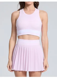 Close-up detail of the pink pleated tennis skirt and athletic crop top with white stripes