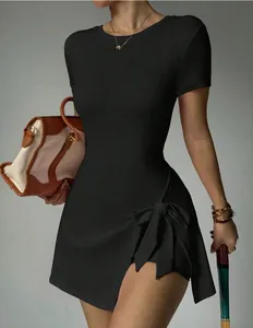 Gros plan sur la mini-robe de sport noire avec nœud latéral et coupe ajustée.