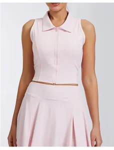 Detalle de un top de tenis rosa sin mangas con cuello de polo y cremallera frontal.