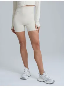 Professional high-waisted cream yoga shorts featuring body-hugging fit and quick-dry fabric.